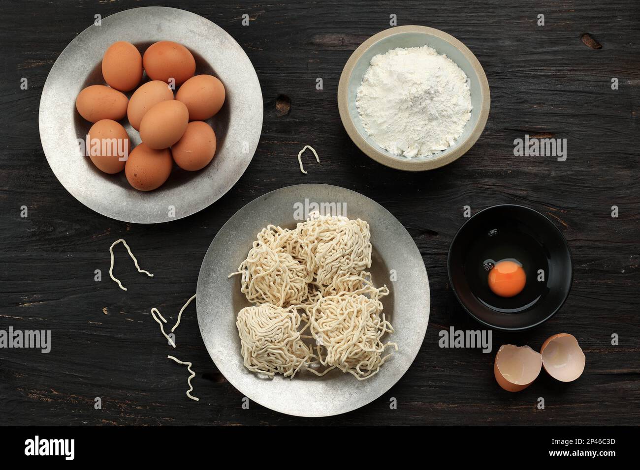 Tagliatella bianca grezza asiatica dell'uovo, vista dall'alto sulla tavola di legno Foto Stock