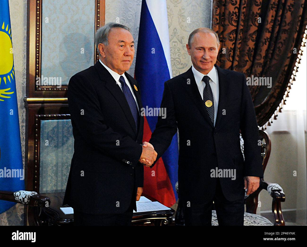 Russian President Vladimir Putin, right, and Kazakh President Nursultan Nazarbayev shake hands at the Shanghai Cooperation Organization summit in Dushanbe, Tajikistan, Friday, Sept. 12, 2014. (AP Photo/RIA Novosti, Mikhail Klimentyev, Presidential Press Service) Foto Stock