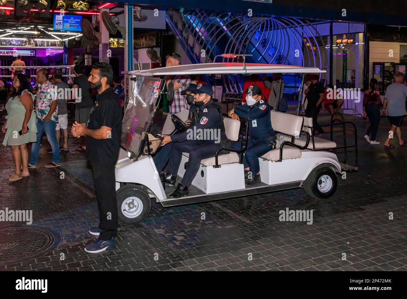 Polizia turistica tailandese guida veicolo elettrico sulla strada pedonale di notte, Pattaya, Thailandia Foto Stock
