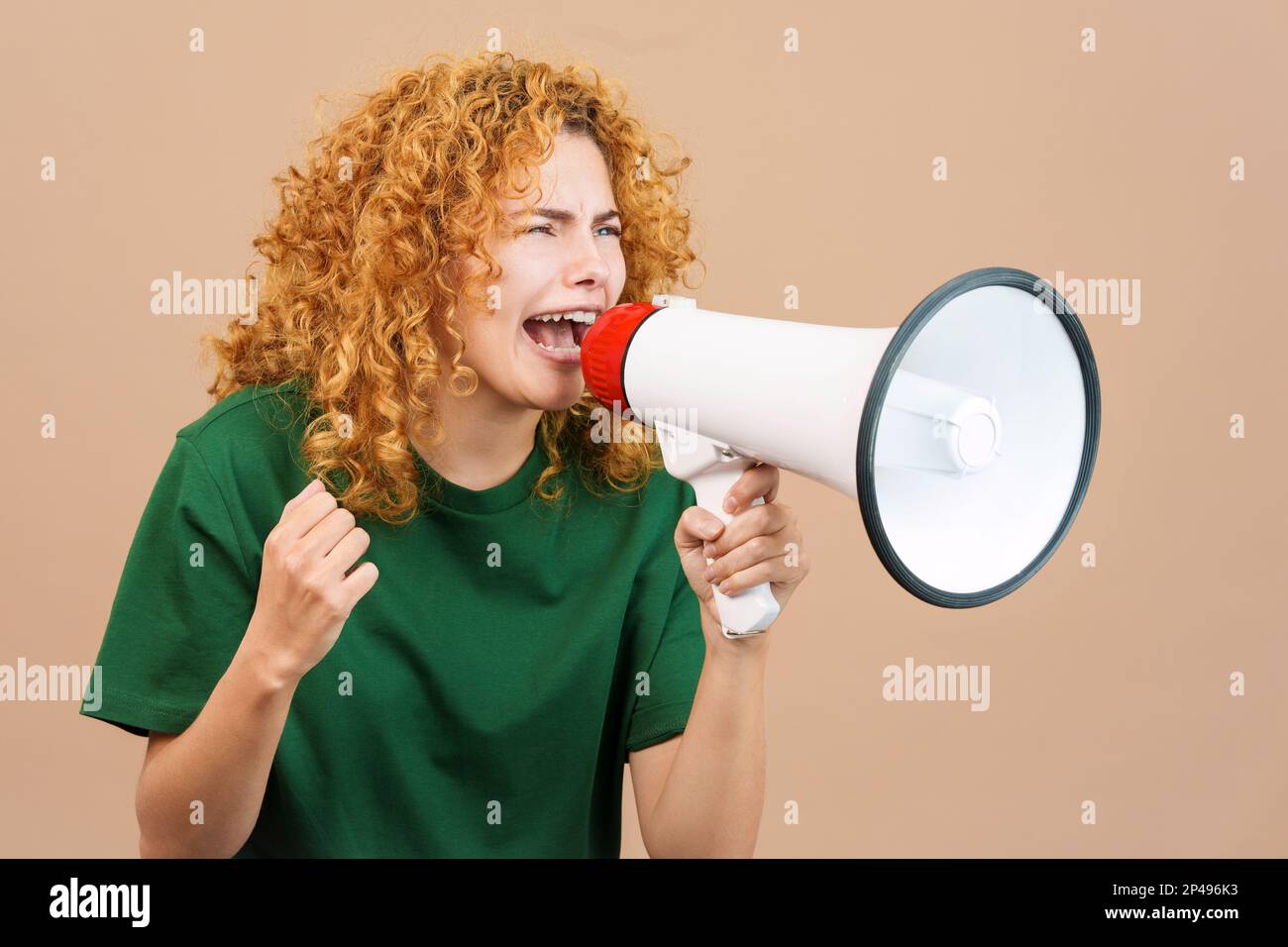 Donna sconvolta con capelli ricci urla usando un altoparlante Foto Stock
