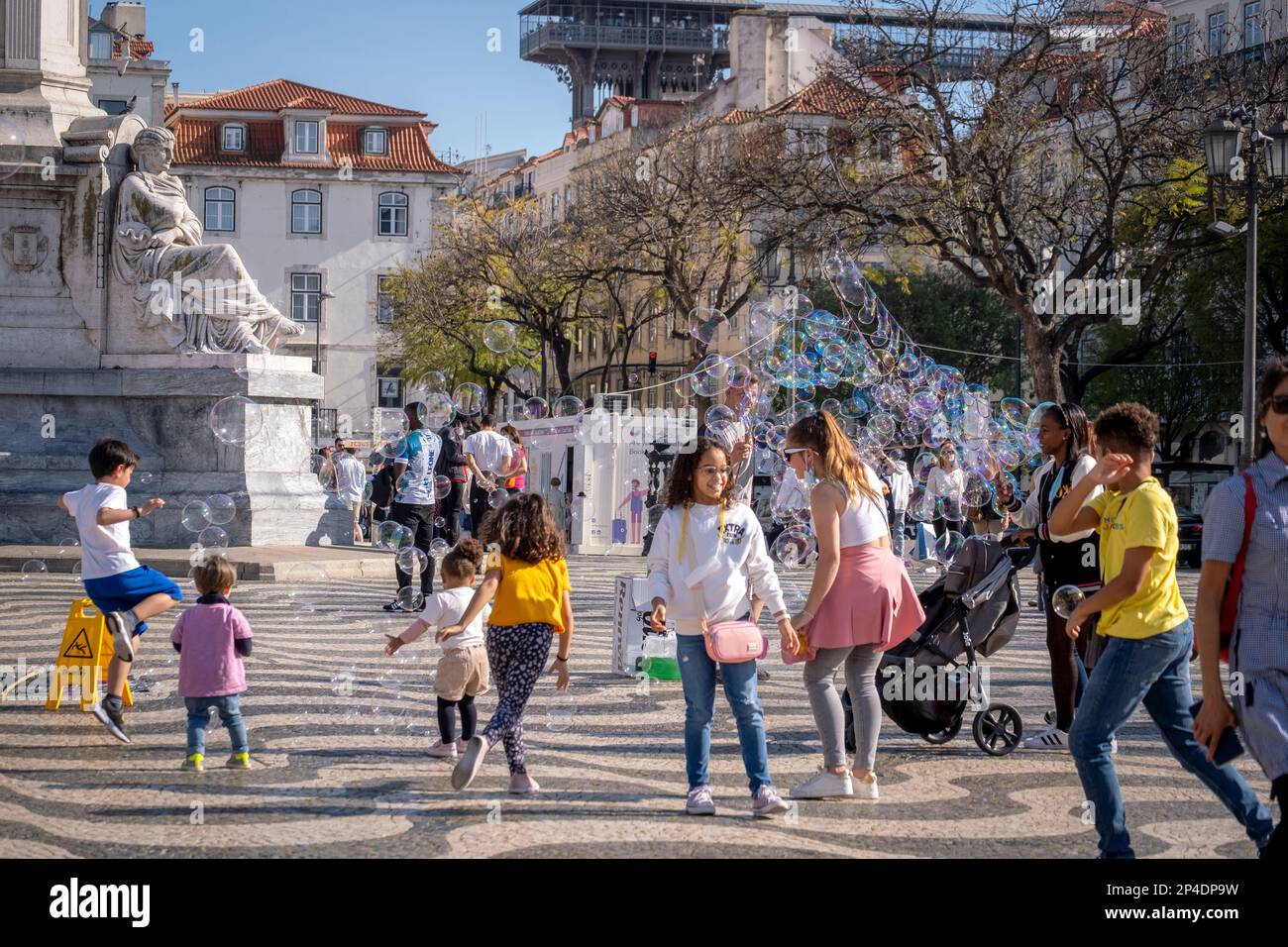Bambini che giocano con le bollicine in un parco a Lisbona, Portogallo Foto Stock