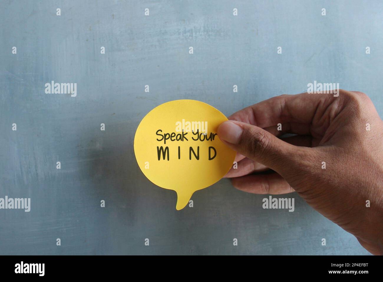 Vista dall'alto immagine della mano che tiene la bolla del discorso con il testo parla la TUA MENTE. Concetto di virgolette motivazionali Foto Stock