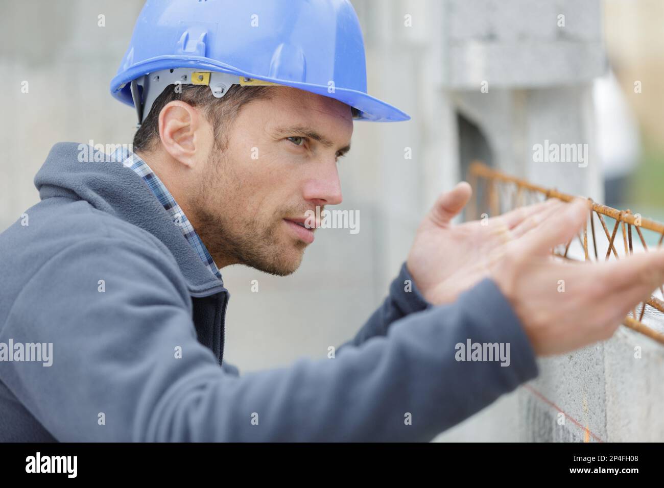 l'uomo sta costruendo un muro di cemento Foto Stock