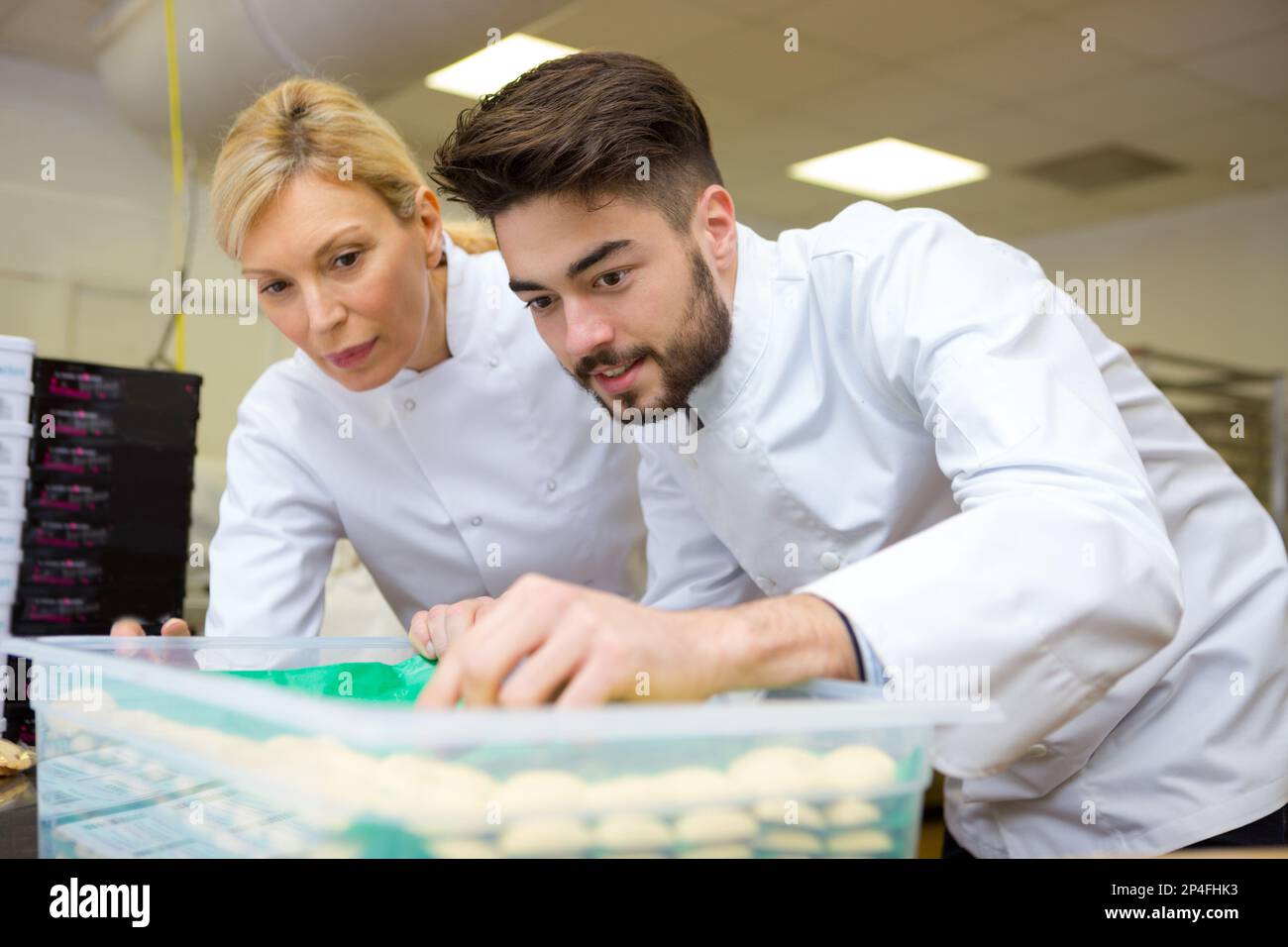 due chef in cucina sorridenti Foto Stock