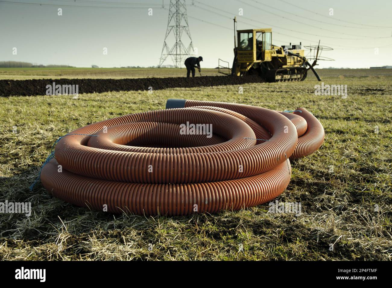 Drenaggio sul campo, posa di tubi e tubi continui in agricoltura arabile, Pilling, Lancashire, Inghilterra, Regno Unito Foto Stock