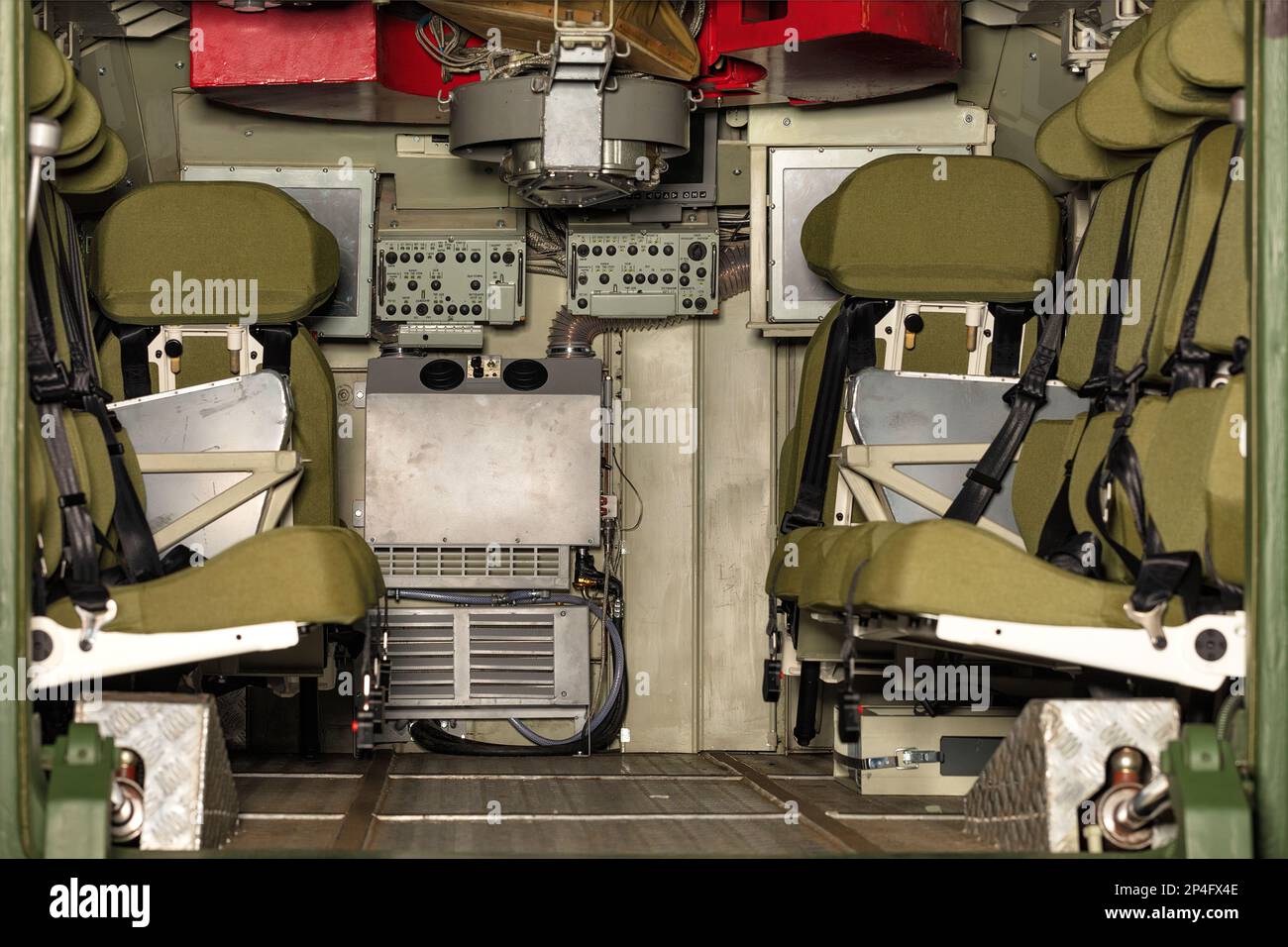 L'interno di un veicolo da combattimento di fanteria blindata con file di sedili e una console di monitoraggio. Foto Stock