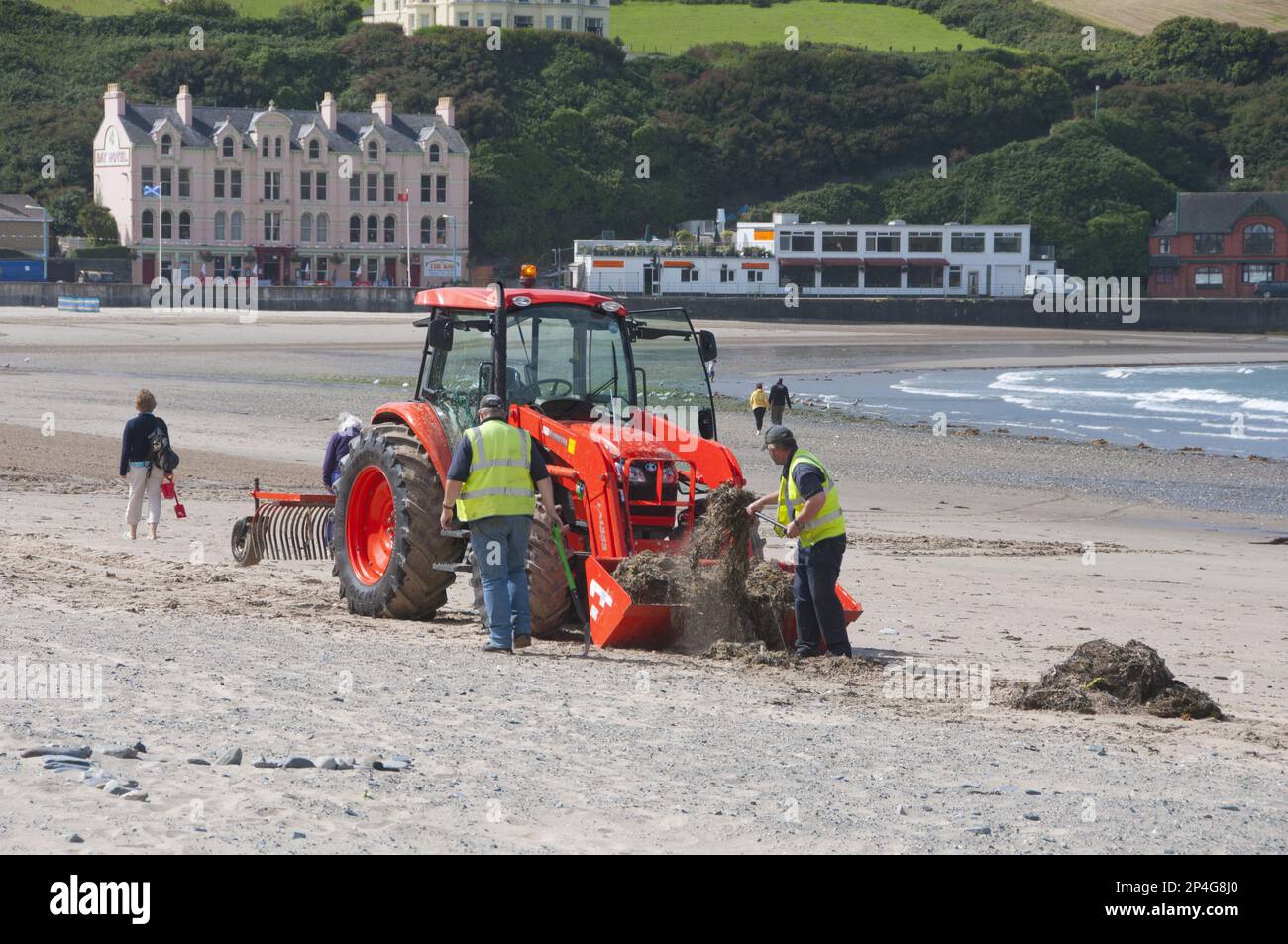 Lavoratori con trattore in spiaggia, pulizia di alghe e rifiuti dalla spiaggia sabbiosa, Port Erin, Isola di Man Foto Stock