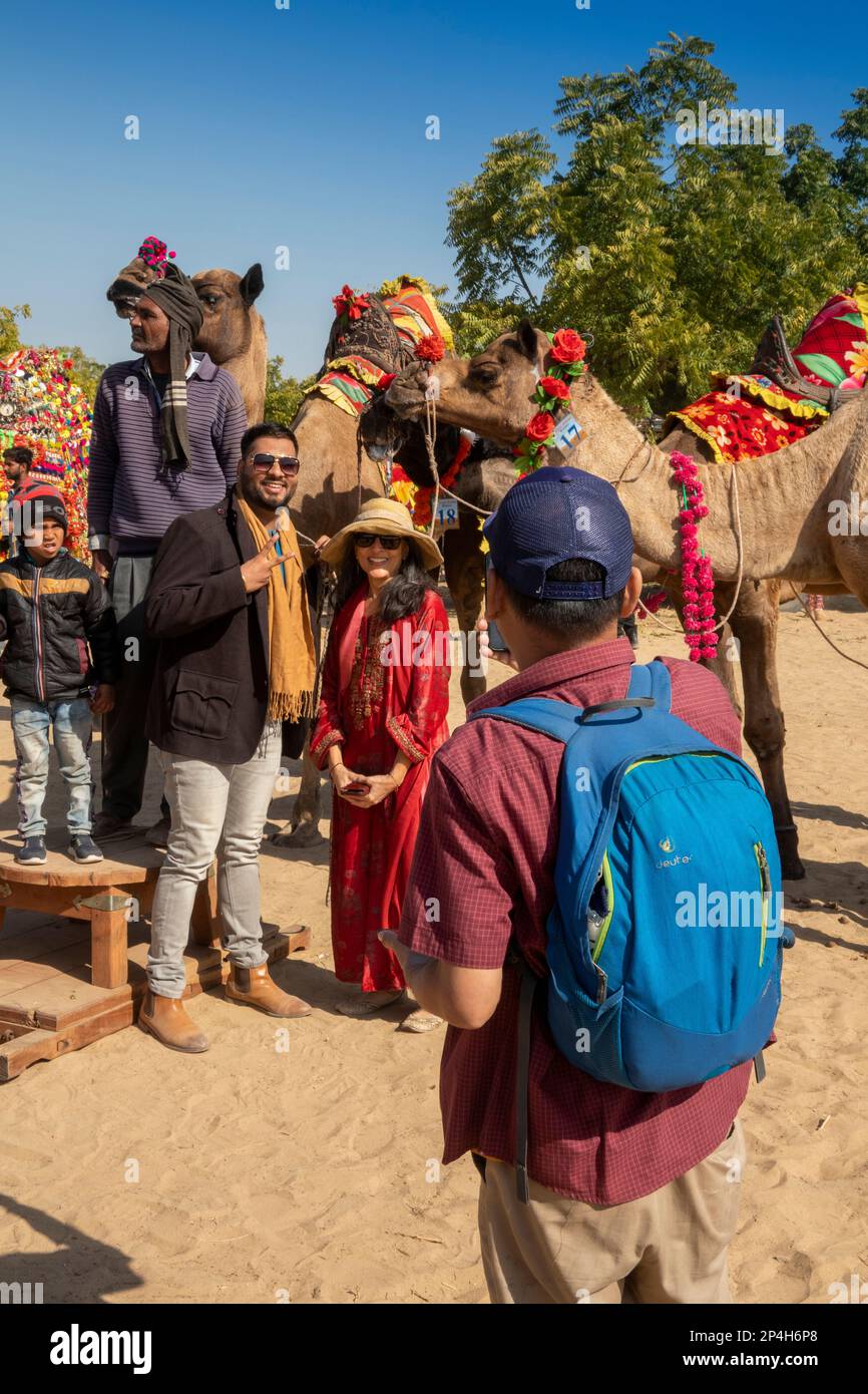India, Rajasthan, Bikaner, Camel Festival, coppia che ha ricordo fotografia scattata accanto ai cammelli decorati Foto Stock