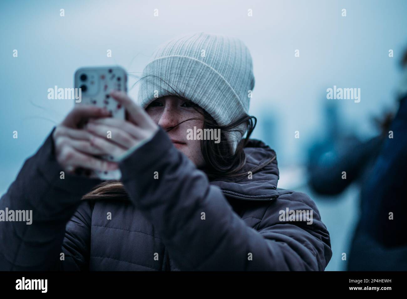 Ragazza teen che scatta una foto in una giornata fredda Foto Stock