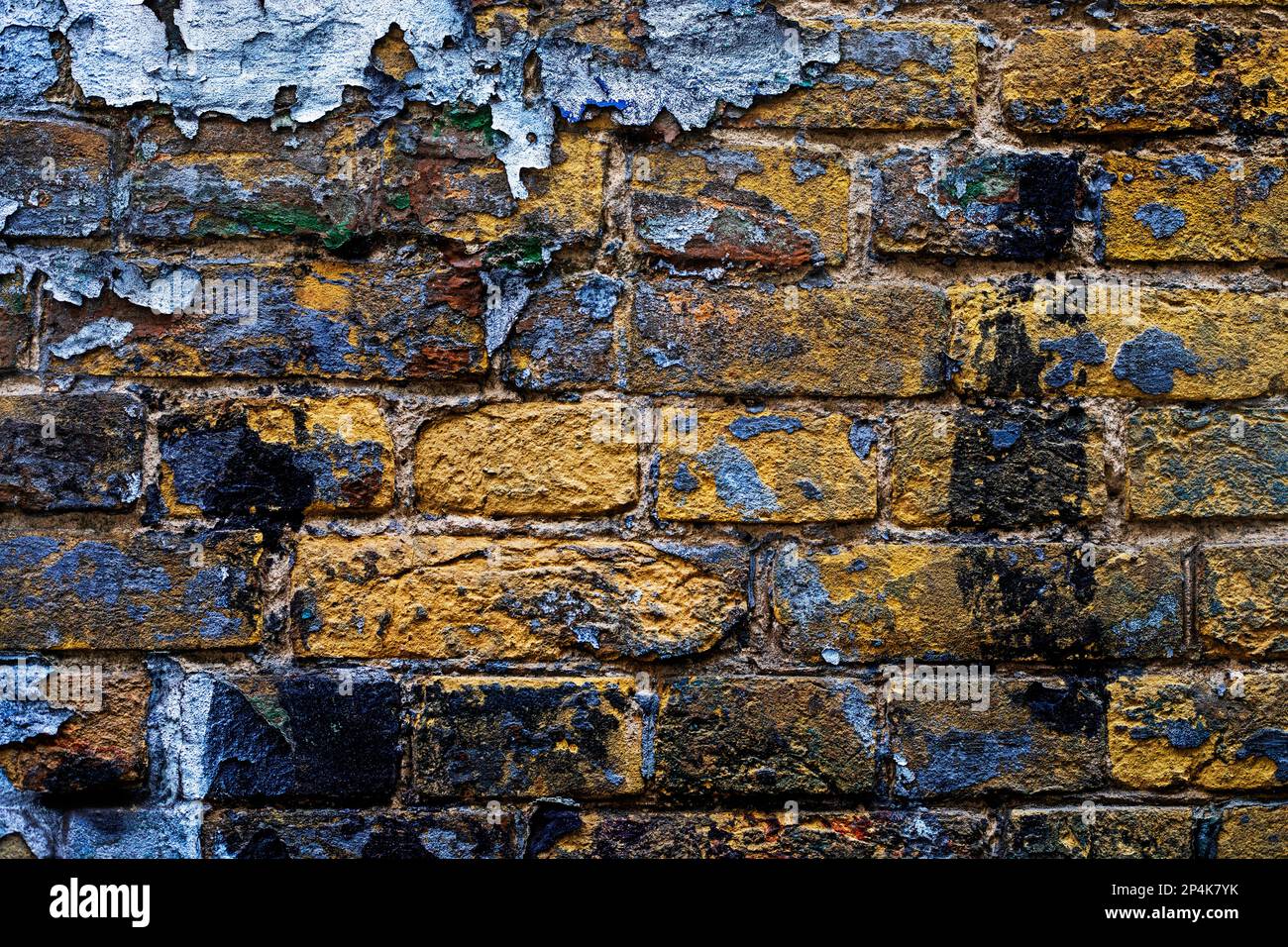 sfondo astratto di mattoni gialli del deposito con vernice scabby vicino al conchiglie. Guerra Foto Stock