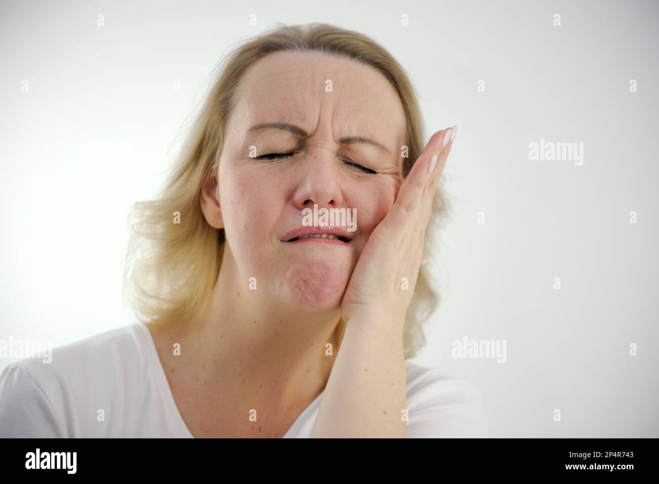 insopportabile mal di denti donna chiuso gli occhi mettere mano al suo posto guancia sinistra per il testo andare al medico non ritardare il trattamento dentale corretta nutrizione è necessario proteggere i denti Foto Stock