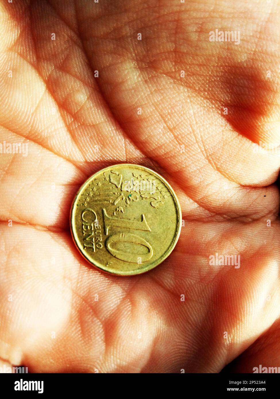 10 centesimi di moneta in una mano Foto Stock