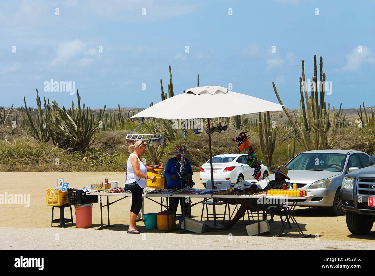 Alto Vista, Noord, Aruba - 10 marzo 2022. Un venditore di strada che vende souvenir da un tavolo in un mercato all'aperto, sul parcheggio dell'Alto Vista Foto Stock