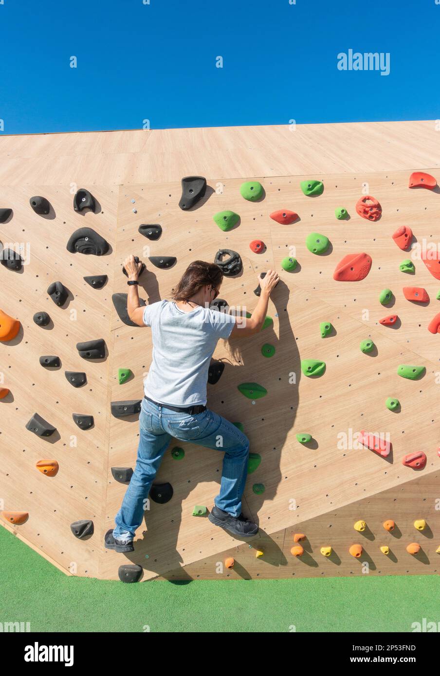 Donna spagnola matura che si arrampica sulla parete di arrampicata all'aperto. Foto Stock