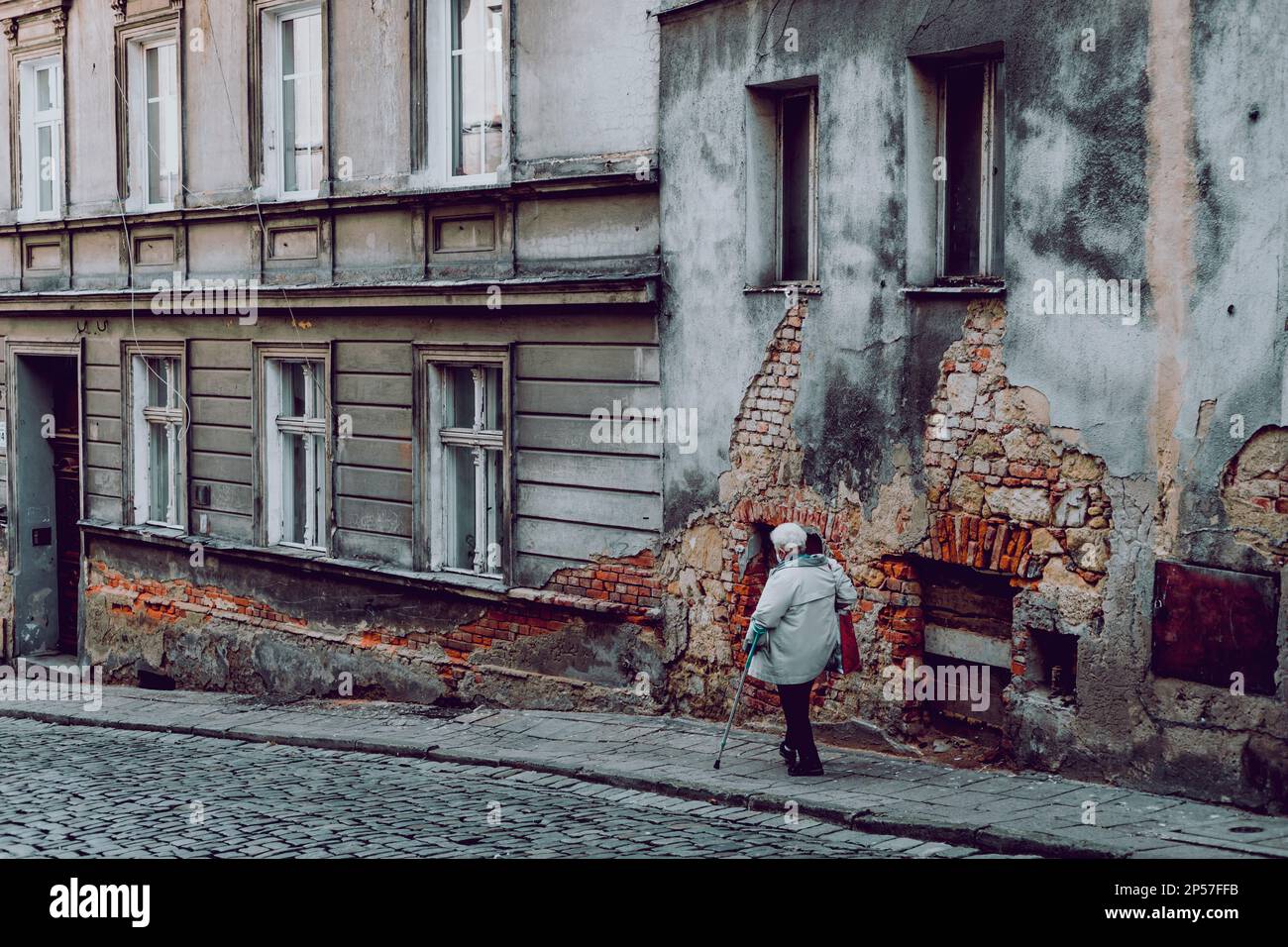 donna sulla strada di edifici in decadenza nella città vecchia Foto Stock