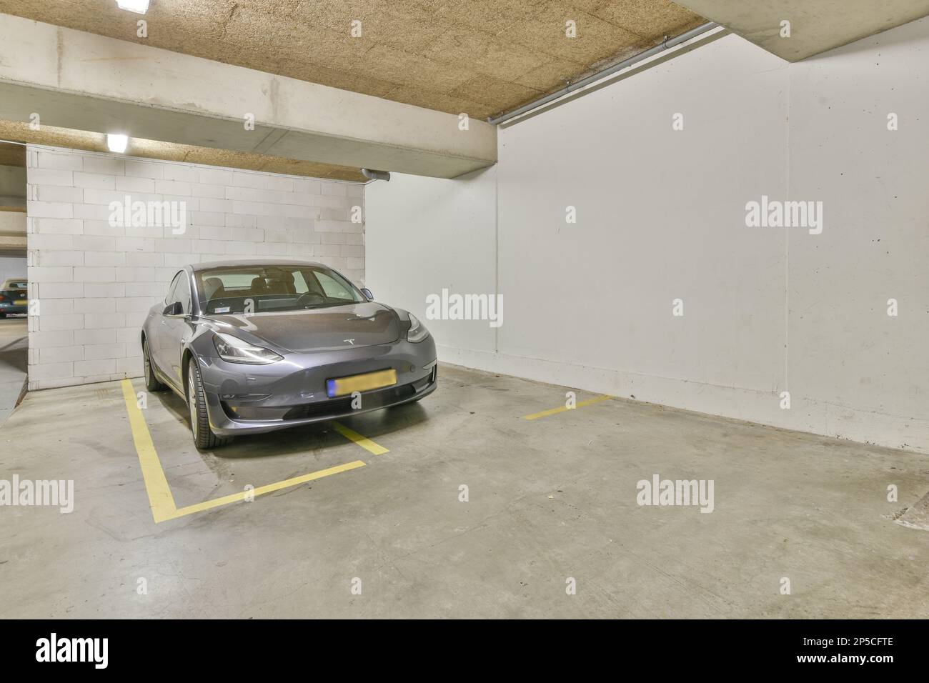 Amsterdam, Paesi Bassi - 10 aprile 2021: Un'auto parcheggiata in un parcheggio con pareti bianche e linee gialle sul pavimento per indicare che non c'è parcheggio Foto Stock