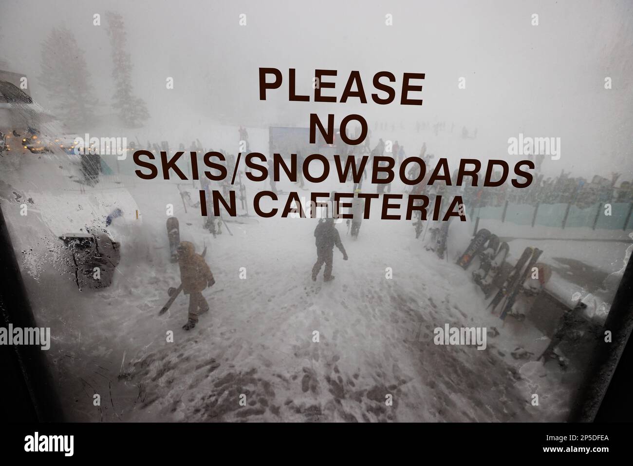 Un cartello indica ai visitatori di non portare sci o snowboard in una caffetteria del resort sciistico di Mammoth Mountain durante un blizzard. Foto Stock