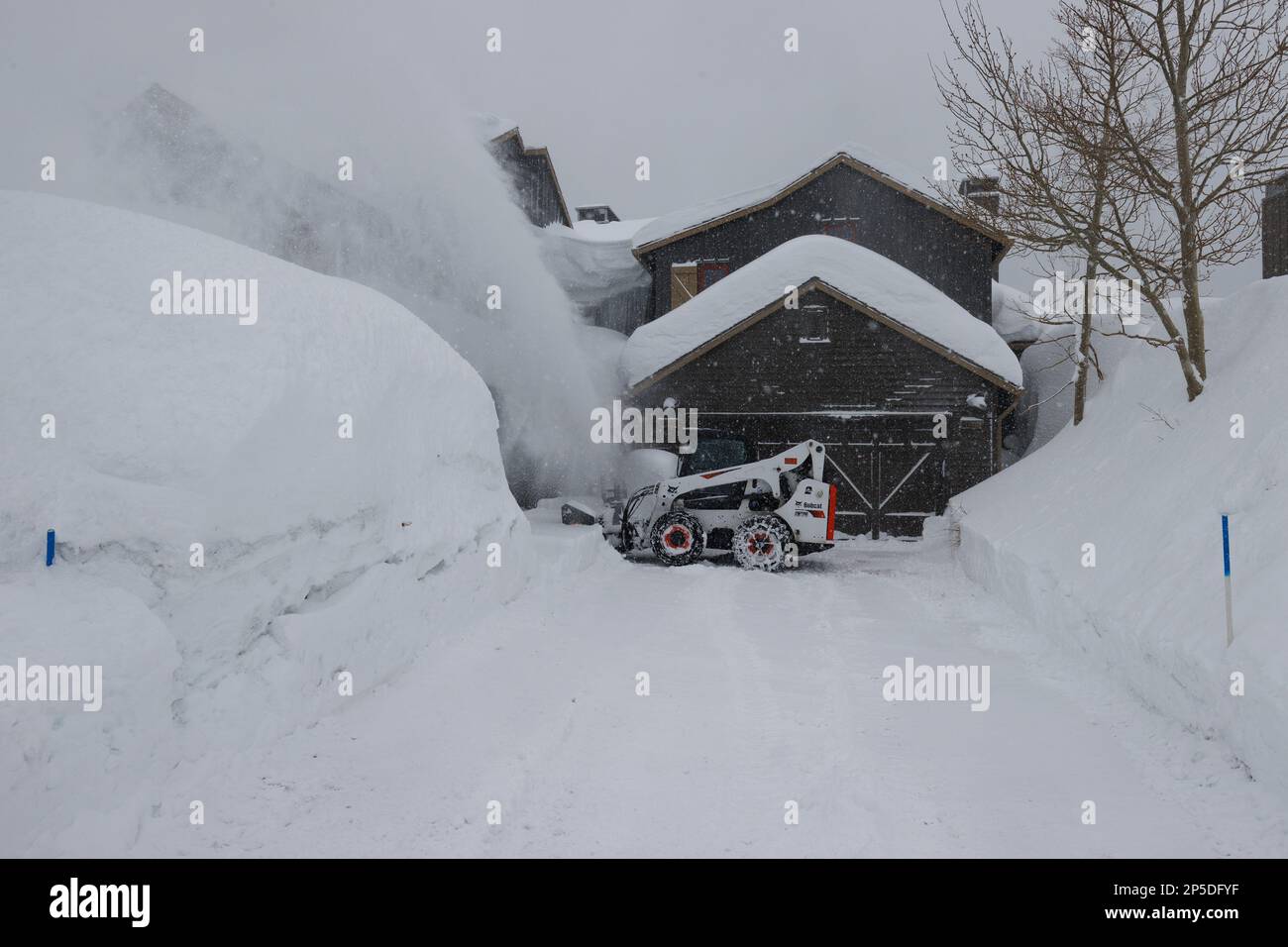 Mammoth Lakes, California. Febbraio 27, 2023. Una macchina per la rimozione della neve elimina la neve da un vialetto residenziale dopo una bufera invernale. Foto Stock