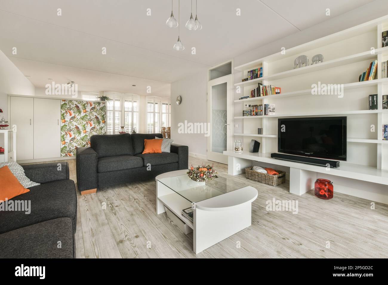 un soggiorno con coulch, tavolino da caffè e televisione a parete nel suo pezzo centrale Foto Stock
