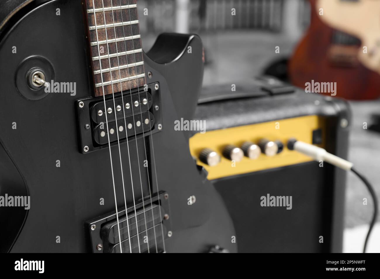 Chitarra elettrica con amplificatore in studio di registrazione, primo piano. Musica band pratica Foto Stock