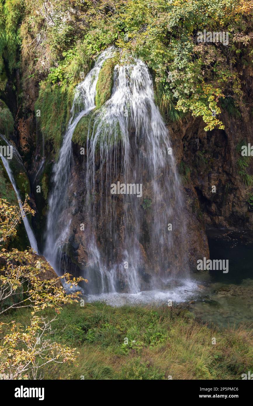 Piccola cascata che esce dal fogliame nel Parco Nazionale dei Laghi di Plitvice Foto Stock