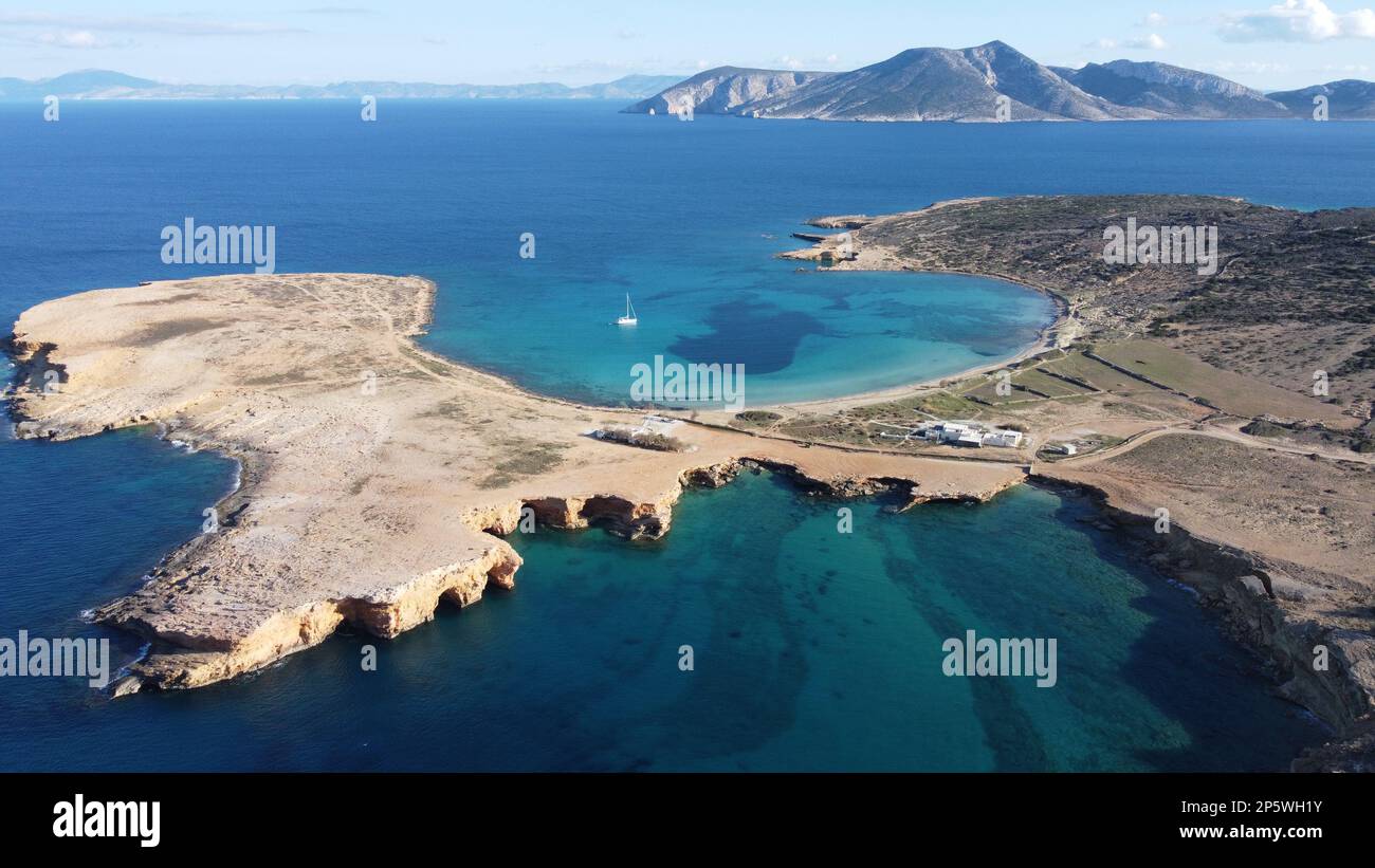 Immagine aerea delle grotte di Ksylompatis che guardano verso la spiaggia di pori dove è ancorata una barca a vela, con l'isola di Amorgos sullo sfondo. Foto Stock