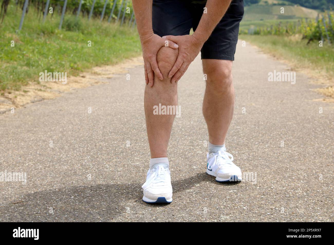 jogger tenendo il ginocchio, dolore al ginocchio Foto Stock