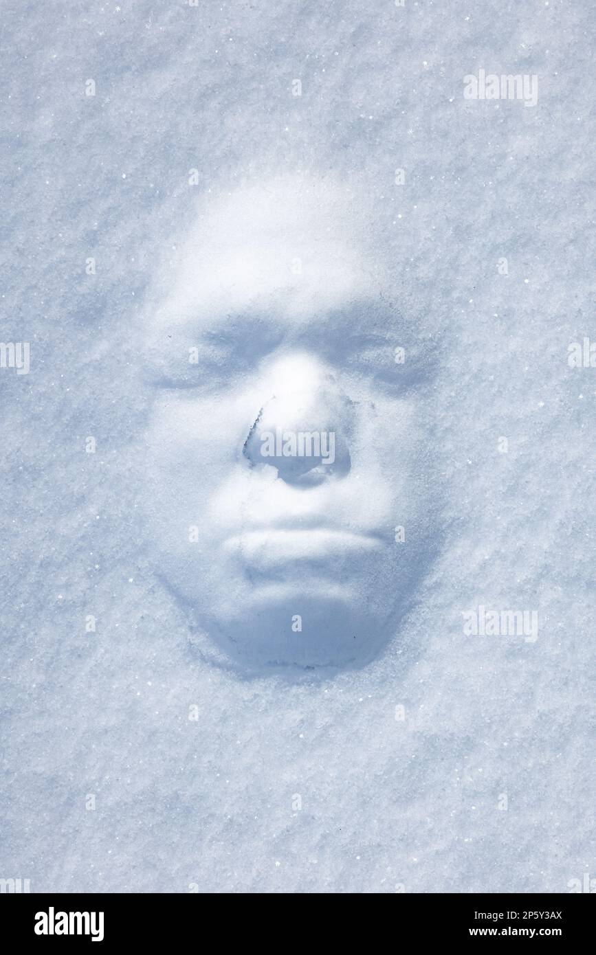 Stampa del volto maschile in una nevicata in una giornata invernale soleggiata Foto Stock