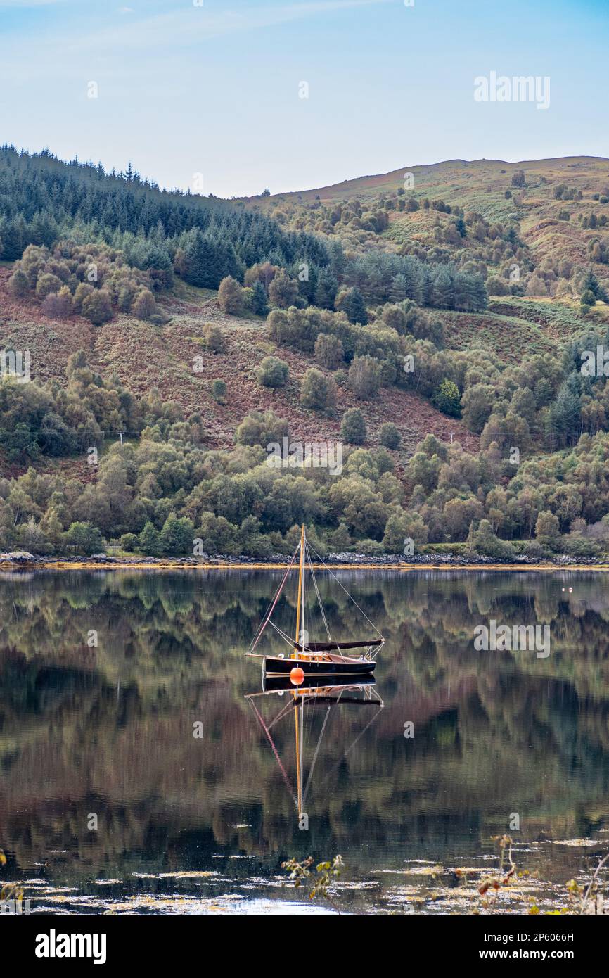 Barca a vela con riflessione all'ancora a Strontian, Loch Sunart Lochaber, Scozia Foto Stock