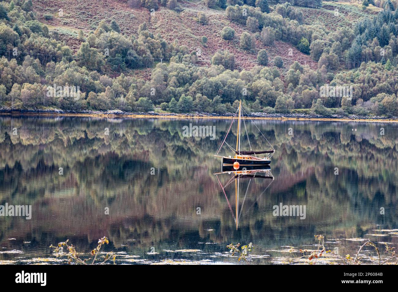 Barca a vela con riflessione all'ancora a Strontian, Loch Sunart Lochaber, Scozia Foto Stock