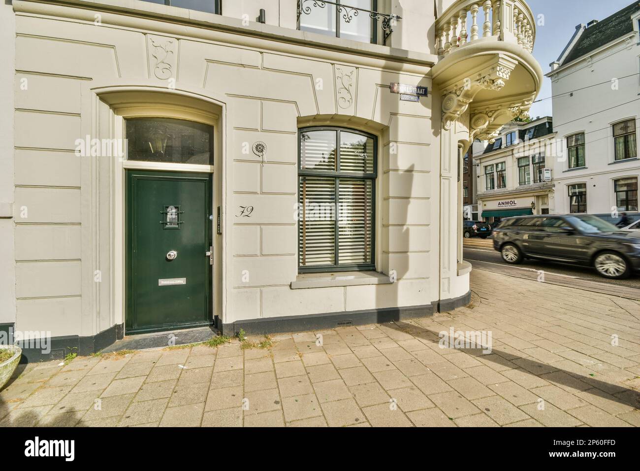 un vecchio edificio con una porta verde e persiane finestre sul lato dell'edificio c'è un'auto parcheggiata di fronte Foto Stock