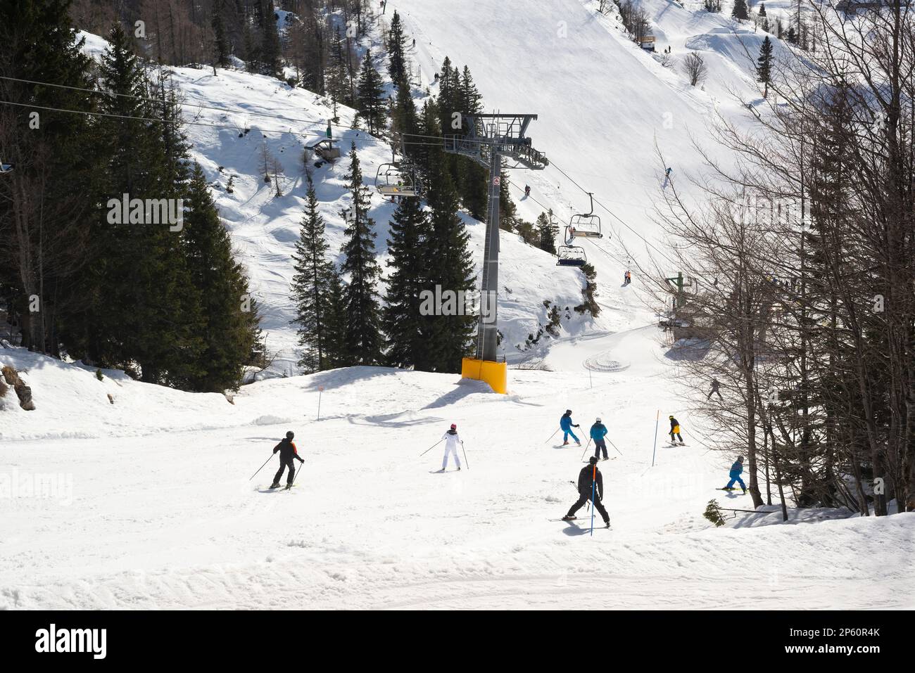 Gruppo di sciatori e snowboarder irriconoscibili sulla pista della stazione sciistica di montagna Foto Stock