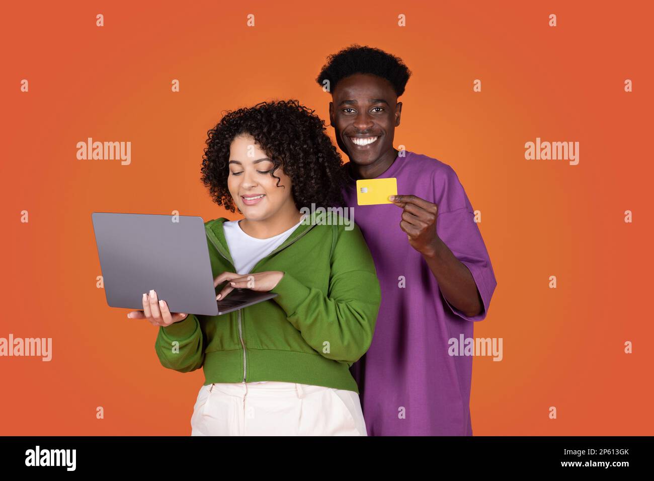 Felici amanti delle corse miste che acquistano online, utilizzando il notebook Foto Stock