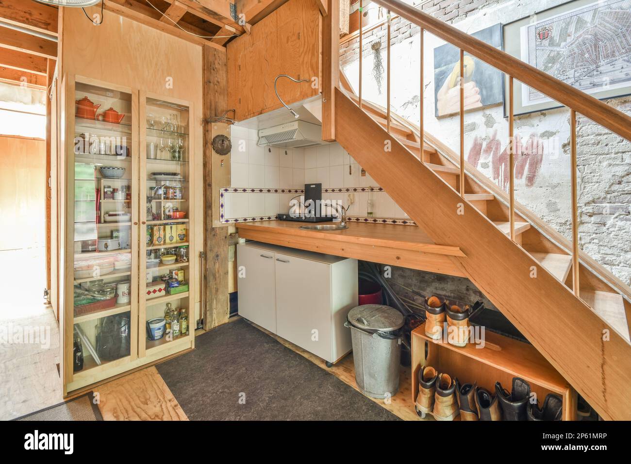 Amsterdam, Paesi Bassi - 10 aprile, 2021: Una cucina sotto le scale in una piccola casa con pareti rivestite in legno e finiture dipinte di bianco intorno alla porta Foto Stock