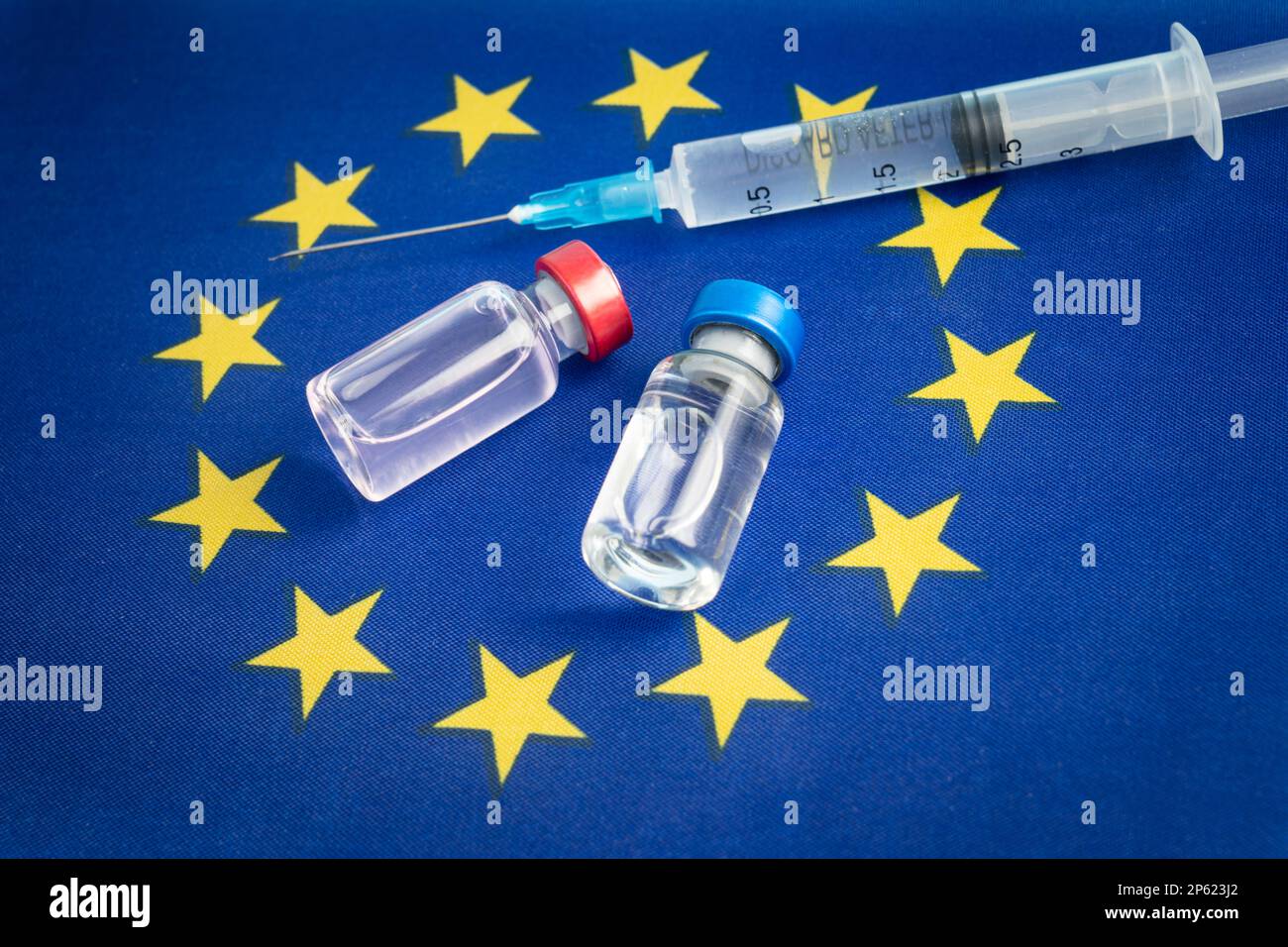 Farmacologia e Medicina concetto dell'Unione europea. vaccino contro il coronavirus covid. Fiale di vaccino, siringa sullo sfondo della bandiera nazionale Foto Stock