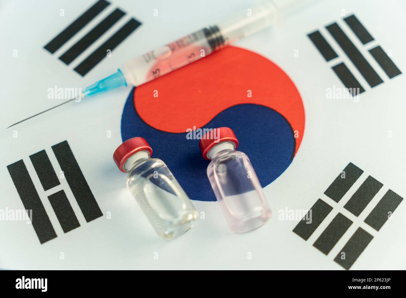 Concetto di farmacologia e medicina Corea del Sud. vaccino contro il coronavirus covid. Fiale di vaccino, siringa sullo sfondo della bandiera nazionale. n Foto Stock