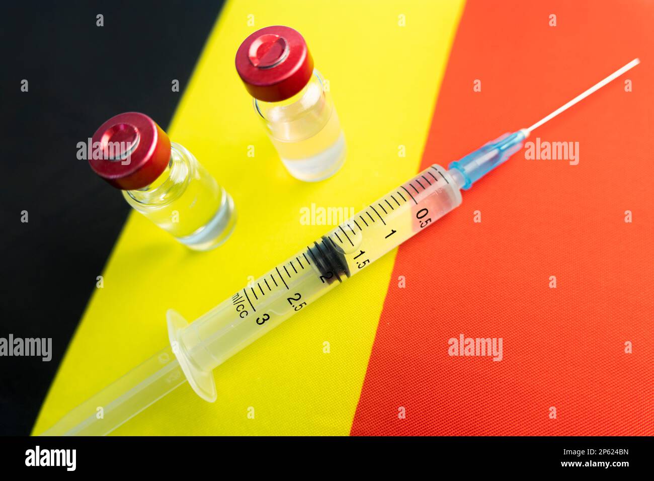 Pharmacology and Medicine Belgium Concept. vaccino contro il coronavirus covid. Fiale di vaccino, siringa sullo sfondo della bandiera nazionale. natio Foto Stock