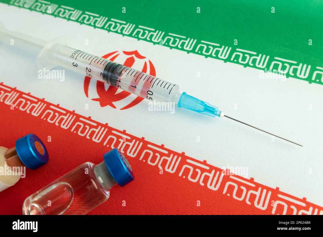 Farmacologia e Medicina iran concetto. vaccino contro il coronavirus covid. Fiale di vaccino, siringa sullo sfondo della bandiera nazionale. nazionale Foto Stock