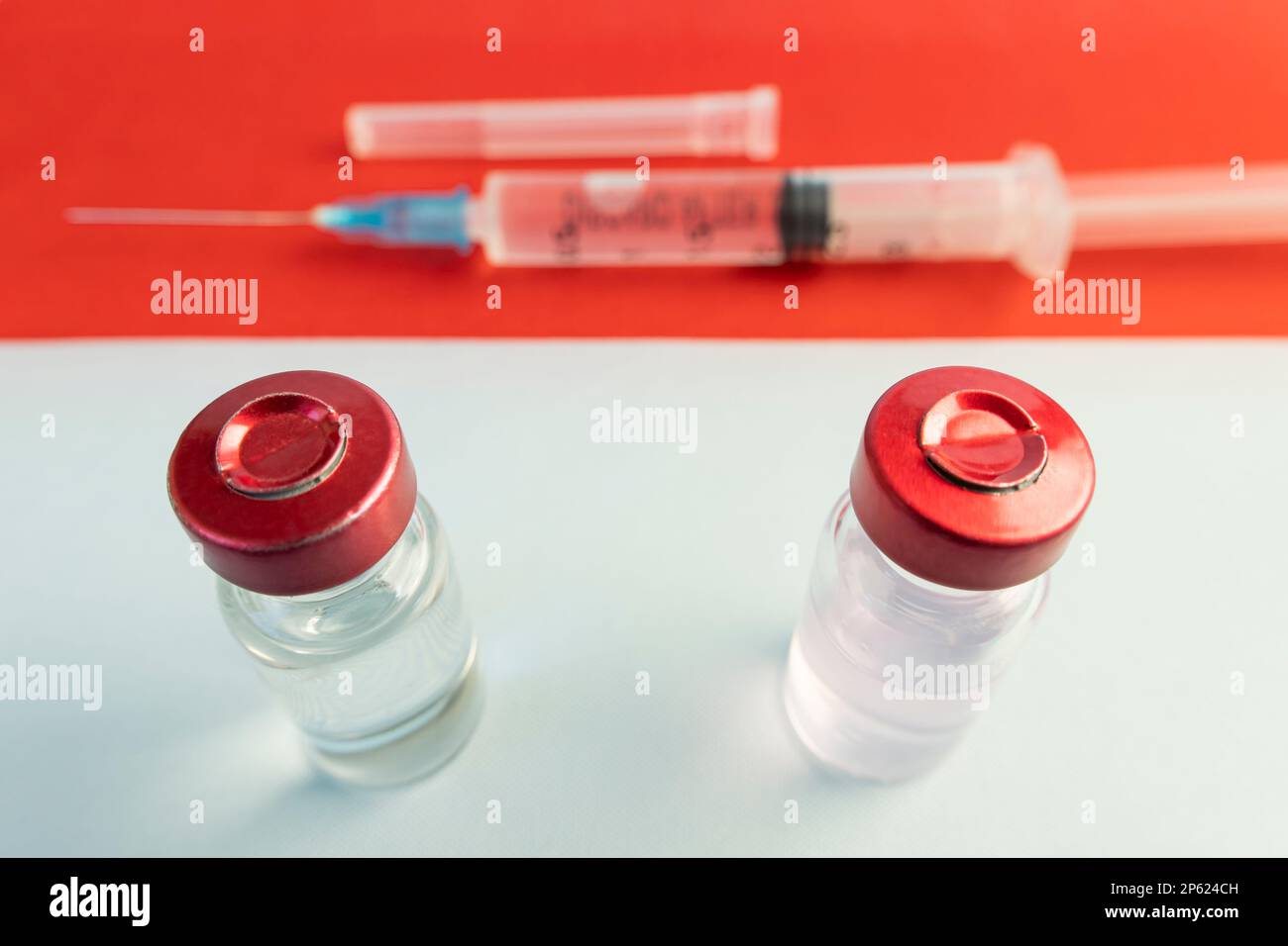 Pharmacology and Medicine indonesia Concept. vaccino contro il coronavirus covid. Fiale di vaccino, siringa sullo sfondo della bandiera nazionale. nat Foto Stock