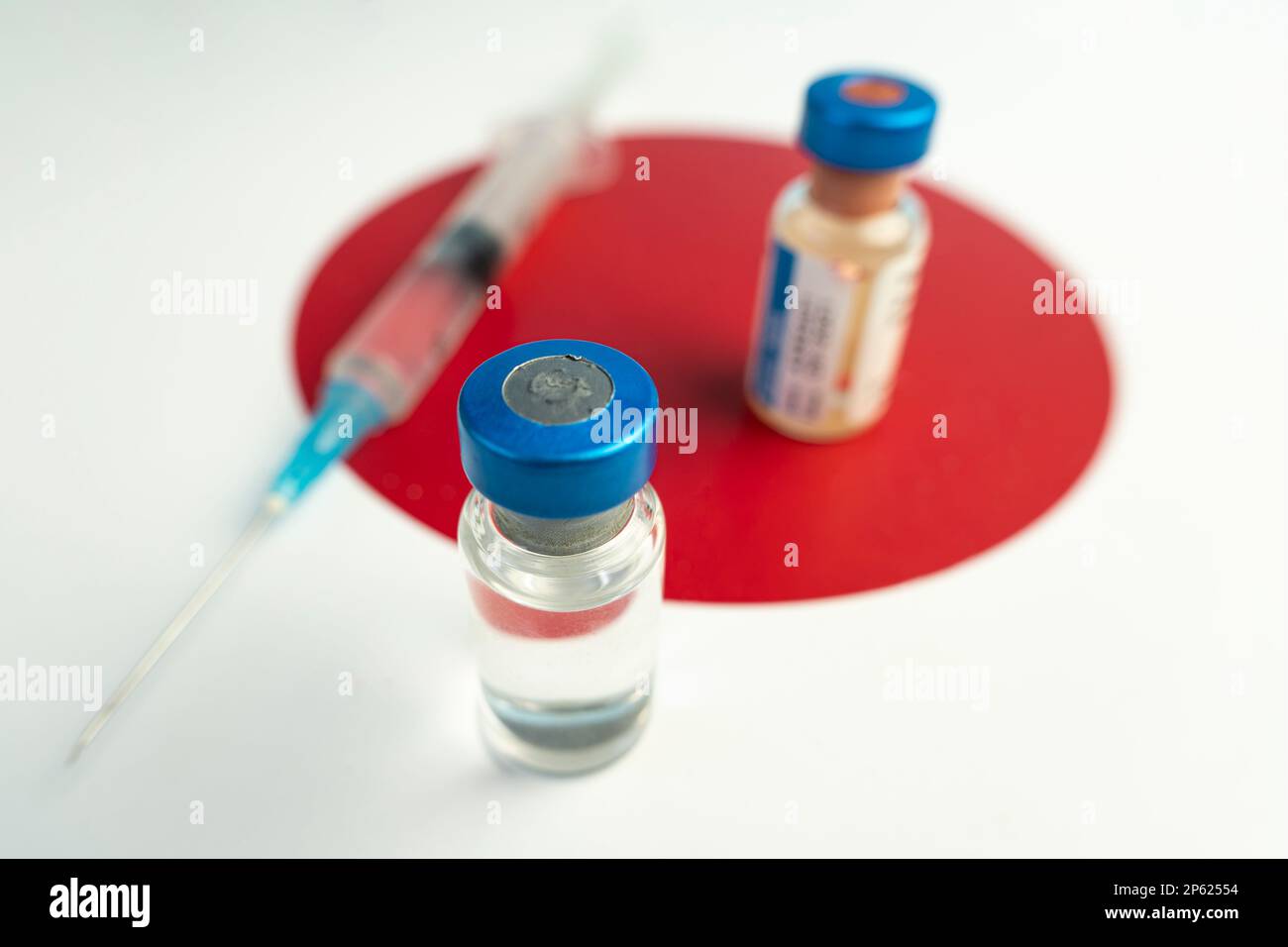 Pharmacology and Medicine Japan Concept. vaccino contro il coronavirus covid. Fiale di vaccino, siringa sullo sfondo della bandiera nazionale. nationa Foto Stock