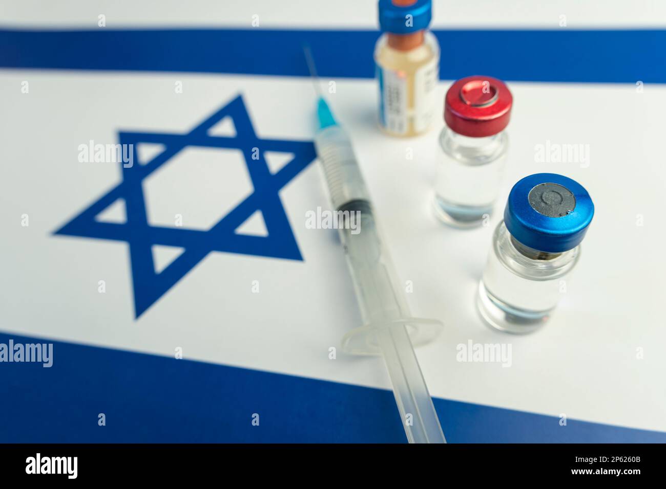 Pharmacology and Medicine Israel Concept. vaccino contro il coronavirus covid. Fiale di vaccino, siringa sullo sfondo della bandiera nazionale. nazione Foto Stock