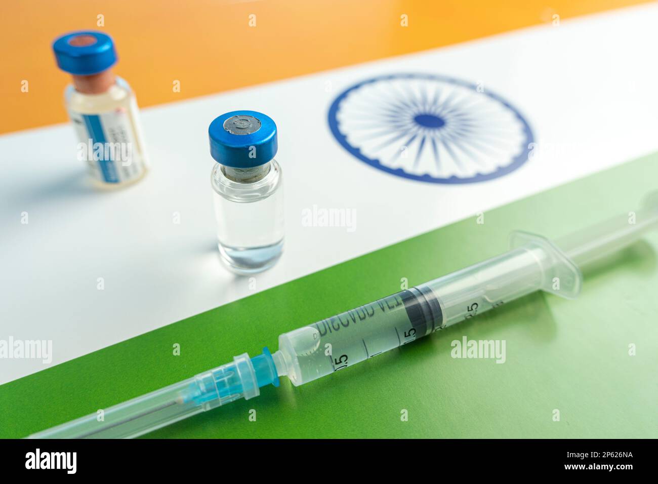 Pharmacology and Medicine India Concept. vaccino contro il coronavirus covid. Fiale di vaccino, siringa sullo sfondo della bandiera nazionale. nationa Foto Stock