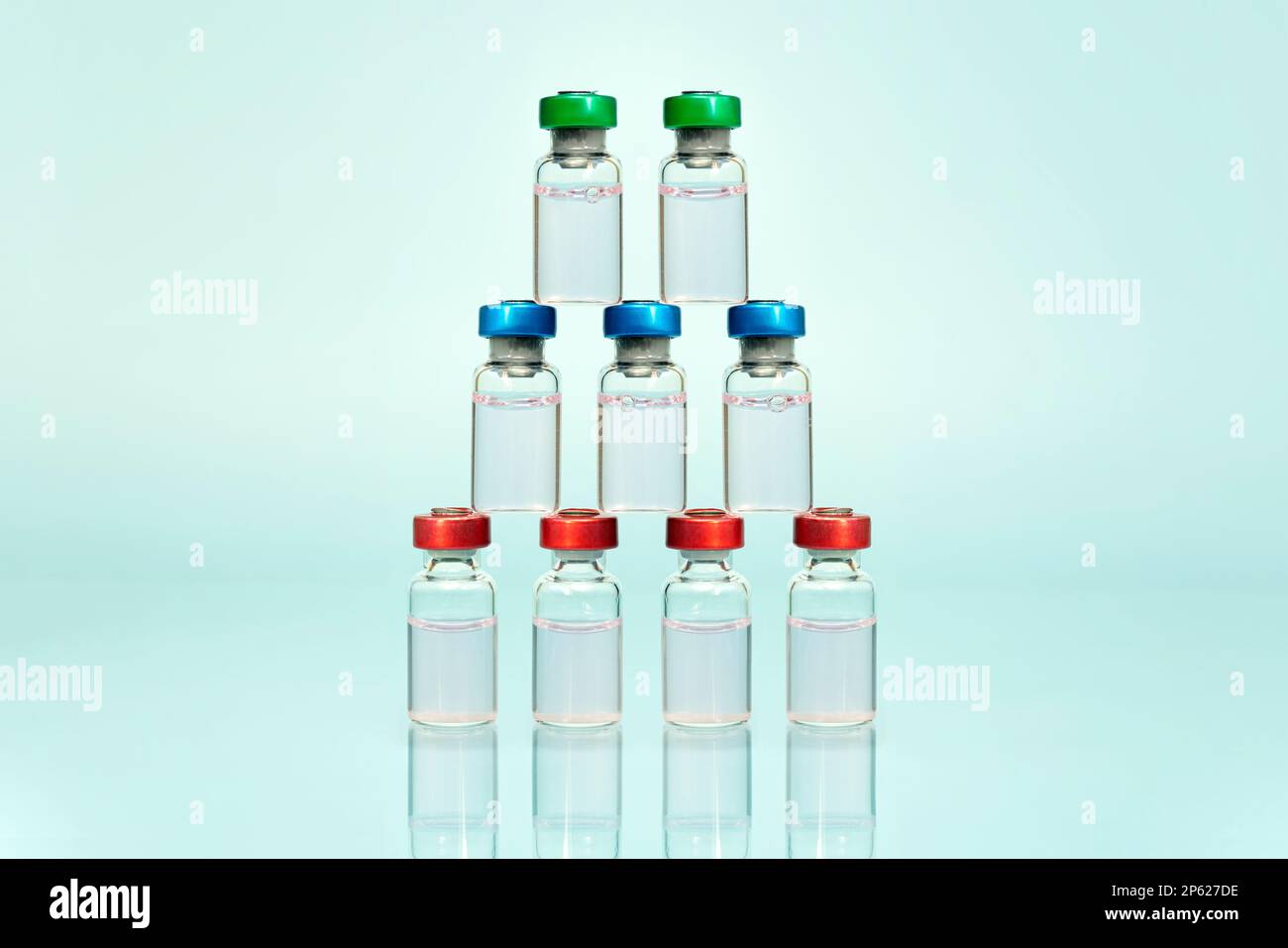 Una collezione di flaconi trasparenti multiuso con tappi colorati, in piedi e disposti su sfondo blu. prodotti farmacologici Foto Stock