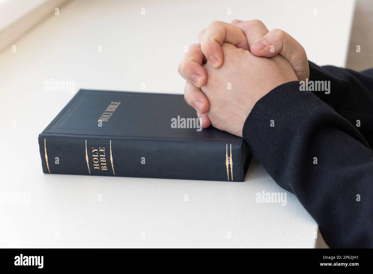 La Sacra Bibbia nelle mani degli uomini. Il concetto di fede e religione. la fede cristiana. Foto Stock
