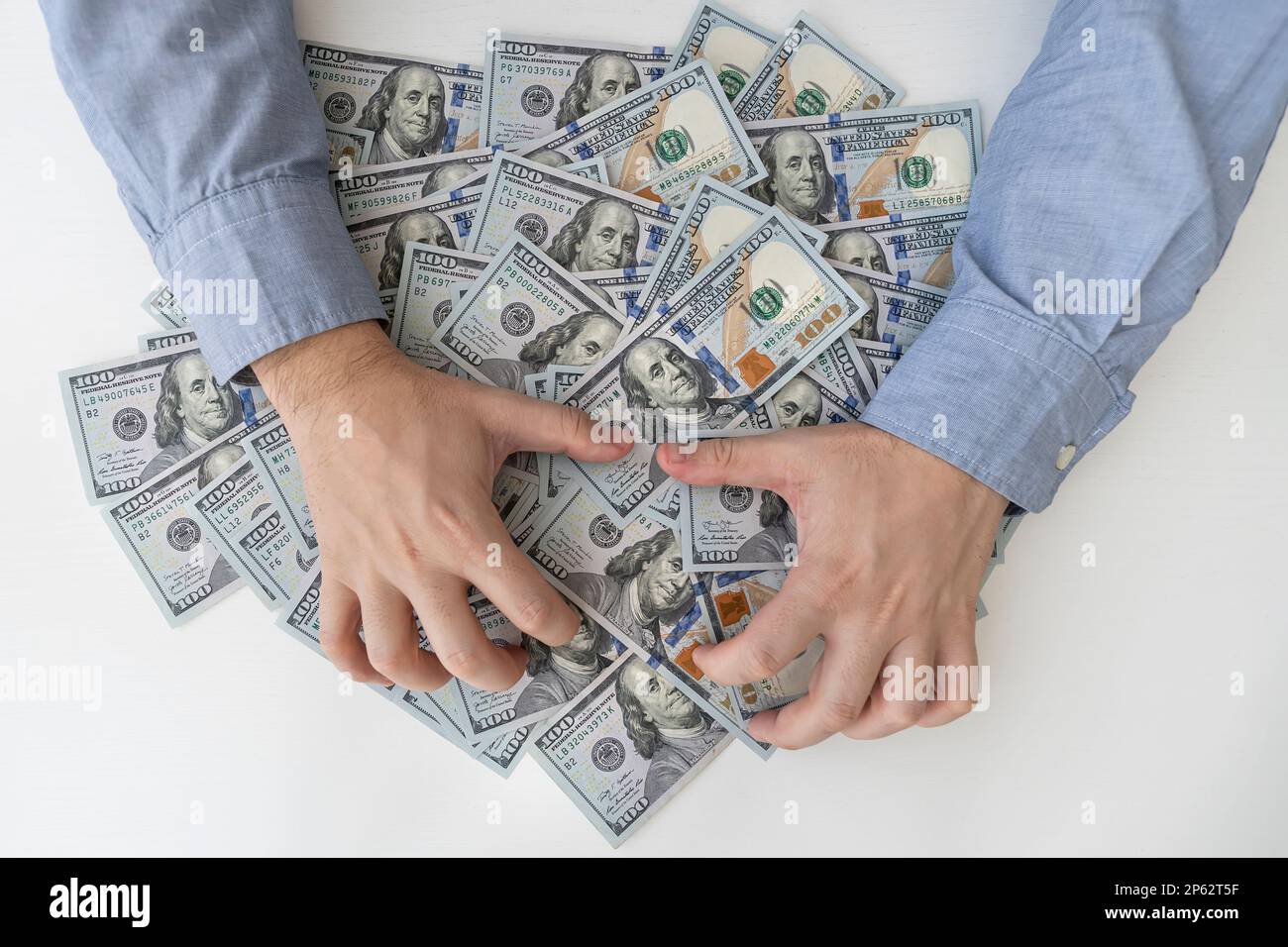 Le mani dell'uomo e le fatture molto del dollaro su un tavolo bianco di legno. Tangenti, corrotti, contanti. Dollari USA in mani maschili. Il concetto di profitto, salari. Foto Stock