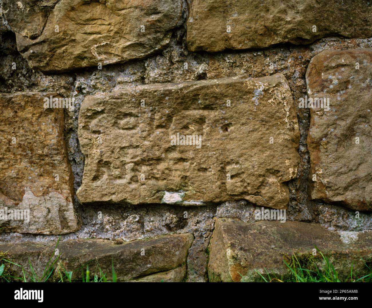Black Carts Centurial Stone, Turret 29a, Vallo di Adriano, Simonburn, Northumberland, Inghilterra. Pietra centuriale riutilizzata nel lato nord del muro romano. Foto Stock
