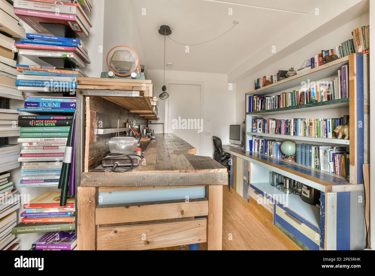 una camera con molti libri sugli scaffali e una libreria aperta nell'angolo  vicino all'isola della cucina Foto stock - Alamy