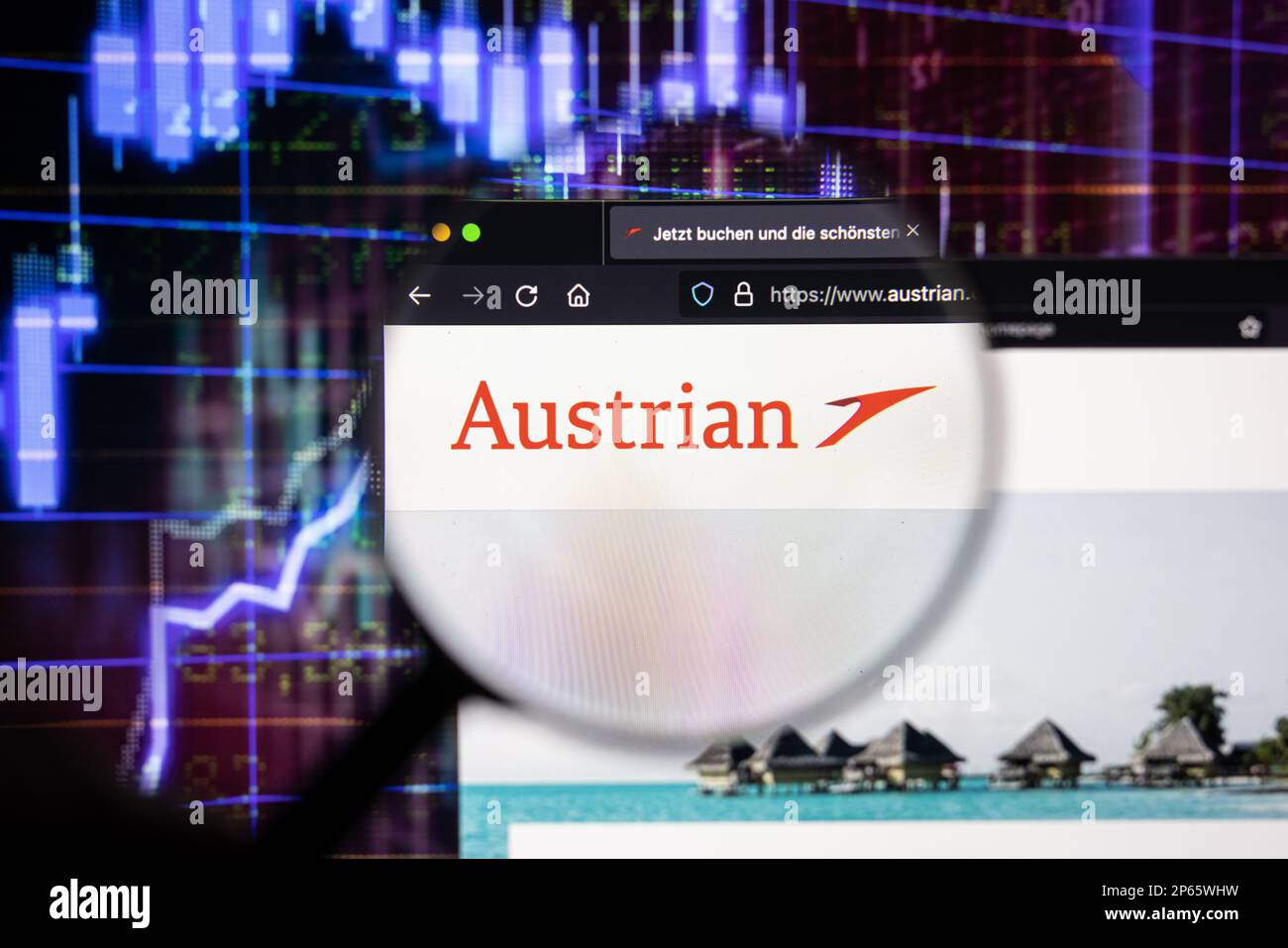 Logo della compagnia aerea austriaca su un sito web con sviluppi sfocati del mercato azionario sullo sfondo, visto su uno schermo attraverso una lente d'ingrandimento Foto Stock