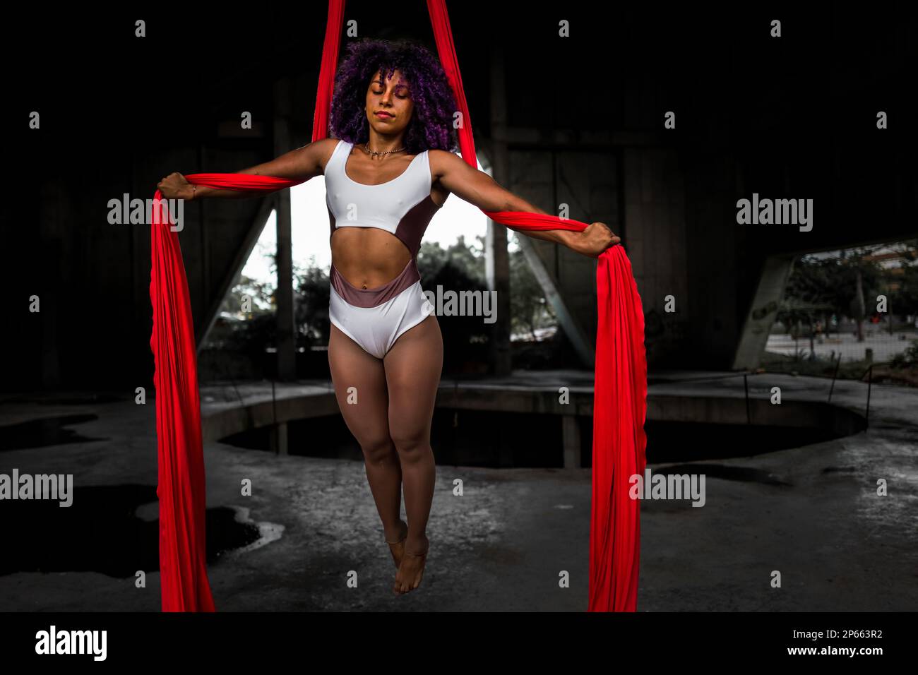 Mariale Contreras, ballerina aerea venezuelana, si esibisce su sete aeree durante una performance artistica in uno spazio industriale a Barranquilla, Colombia. Foto Stock