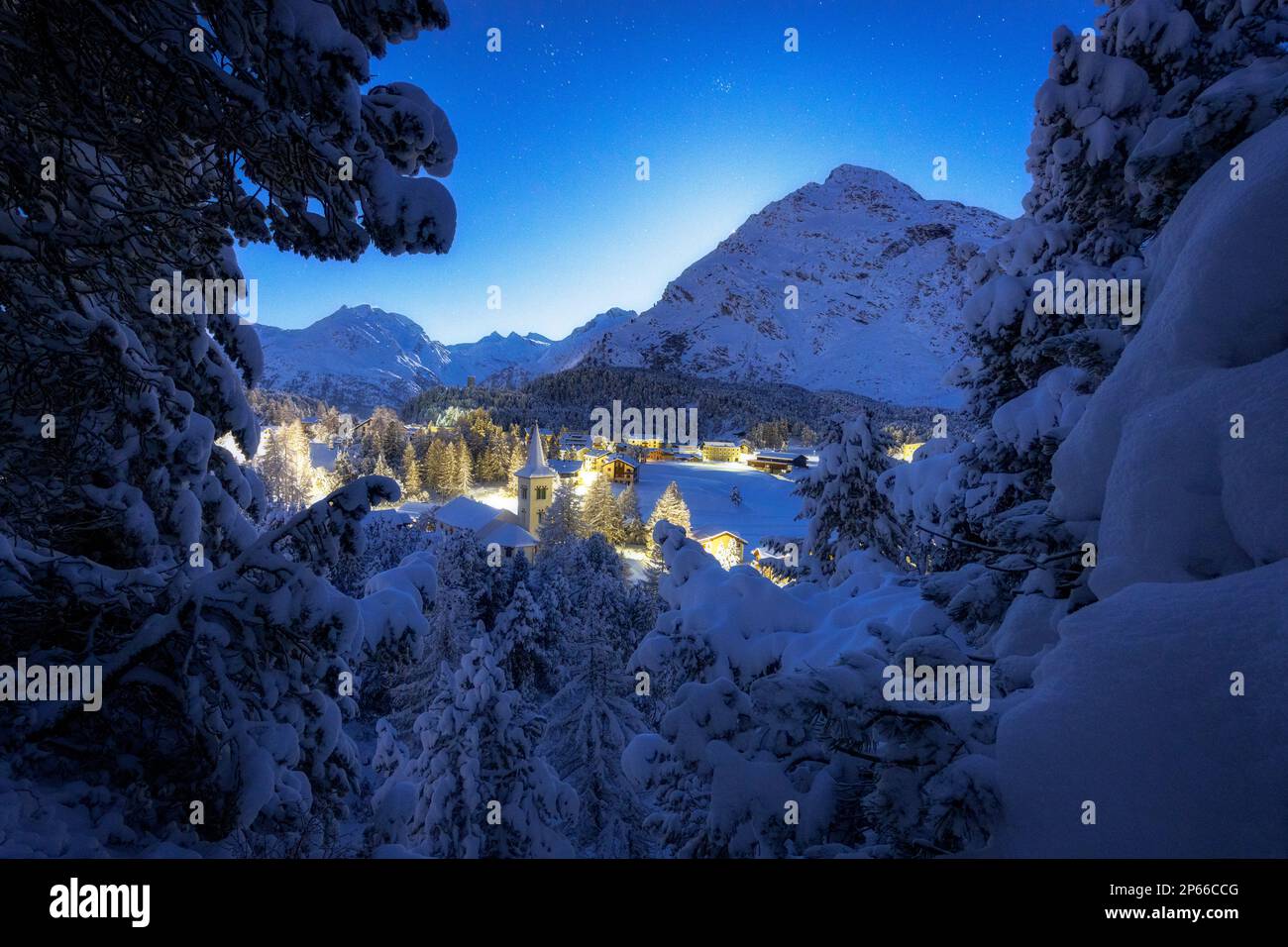 Fiabesco panorama di Chiesa Bianca coperta di neve in una notte stellata d'inverno, Maloja, Bregaglia, Engadina, Cantone di Graubunden, Svizzera, Europa Foto Stock